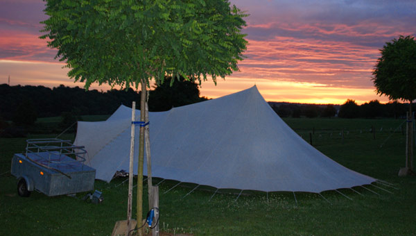 Echtpaar zit relaxed naast hu camper op de camping van Hof van Libeek.