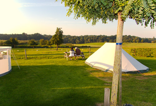 Mensen op bankje bij tent met mooi uitzicht over de Zuid Limburgse heuvels